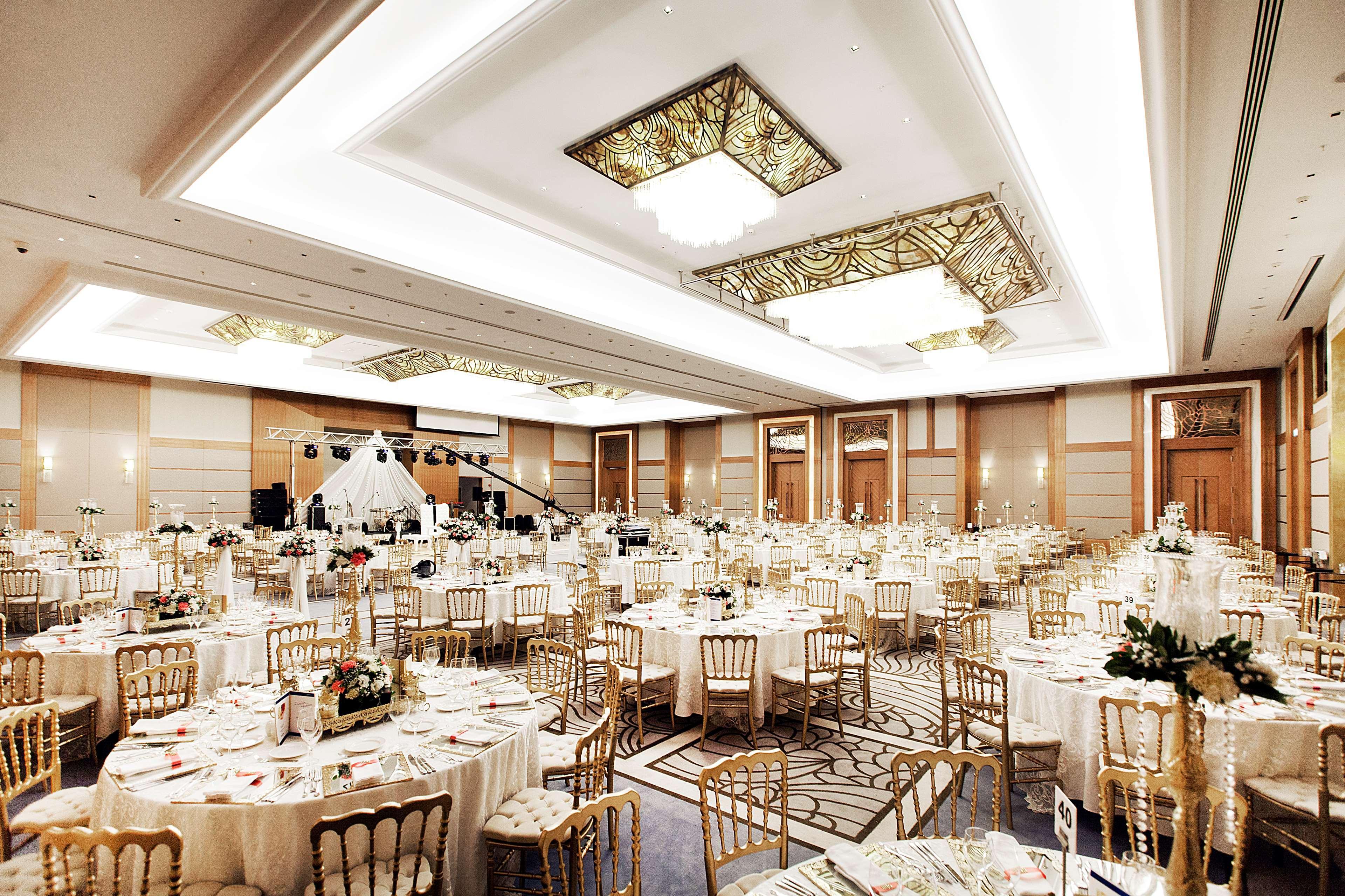 Radisson Blu Hotel, Istanbul Sisli Exterior photo The photo shows an elegant banquet hall set up for an event. The room is adorned with ornate lighting fixtures and has a sophisticated ceiling design. Numerous round tables covered with white tablecloths are arranged throughout the space, each featur